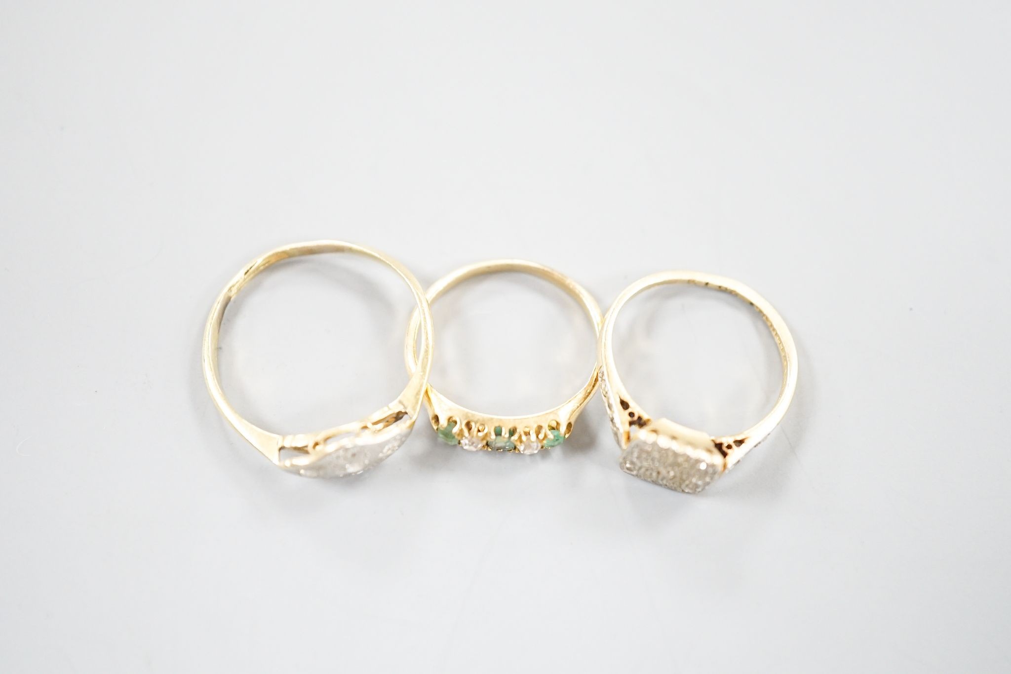 Two 18ct, plat. and diamond chip set dress rings and an 18ct, emerald and diamond set five stone ring, sizes P,I and H/I, gross weight 6 grams.